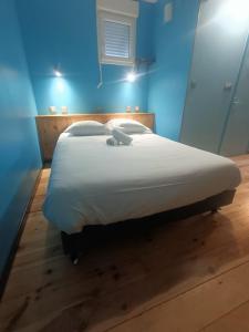- un grand lit blanc dans une chambre bleue dans l'établissement Le gîte du Vivier - Loches, à Loches