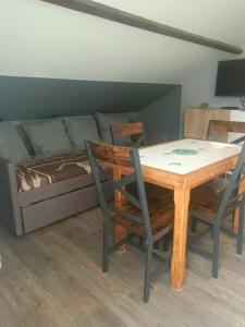 a dining room table with two chairs and a bed at Le gîte du Vivier - Loches in Loches