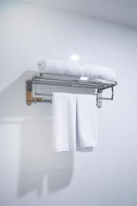 un toallero con toallas en el baño en Kiyana Premiere Hotel Batang en Pekalongan