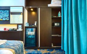 Cette chambre d'hôtel dispose d'un réfrigérateur avec des rideaux bleus. dans l'établissement Selat Al Bait Hotel, à La Mecque