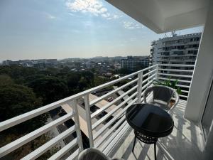 een balkon met een tafel en uitzicht op de stad bij Ningman Road Apartment in Chiang Mai