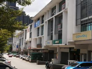 a large white building with cars parked in a parking lot at Hotel Rim Global Pj21 in Kampong Baharu Sungai Way