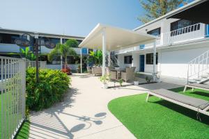 un patio con panchina di fronte a un edificio di Montego Mermaid Beach Motel a Gold Coast