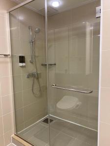 a shower with a glass door in a bathroom at Хайвилл Астана G блок in Promyshlennyy