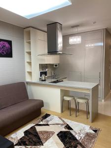 a kitchen with a table and two stools and a couch at Хайвилл Астана G блок in Promyshlennyy