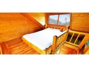 Habitación pequeña con 1 cama en una cabaña de madera en Attene Pension, en Jeju
