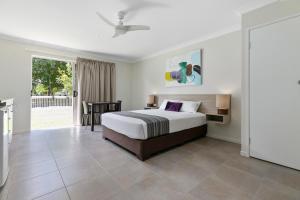 a bedroom with a king sized bed and a table at Beachside Boutique Motel Mackay in Mackay