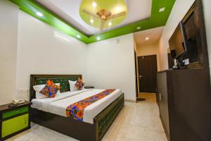 a bedroom with a bed with a ceiling fan at FabHotel Kempty Lake Resort in Mussoorie