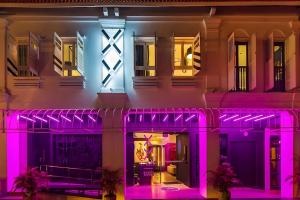 una casa con luci viola sopra la notte di Hi Hotel Bugis a Singapore