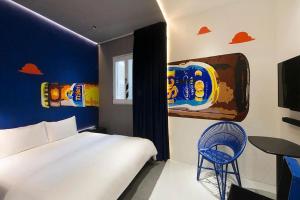 una camera con un letto bianco e una parete blu di Hi Hotel Bugis a Singapore