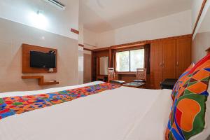 a bedroom with a bed and a flat screen tv at FabHotel Skyry I in Coimbatore