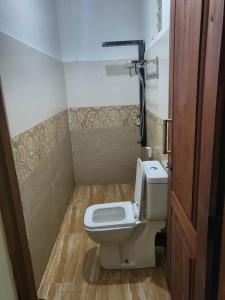 a small bathroom with a toilet and a door at White Villa Kitulgala in Kitulgala