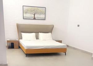 - un lit dans une chambre avec une photo sur le mur dans l'établissement Blpl Manoir, à Karachi
