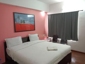 a bedroom with a large bed and a pink wall at Savi's home stay in Ooty
