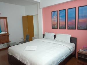 a bedroom with a large bed with a pink wall at Savi's home stay in Ooty