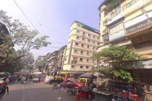 une rue urbaine animée avec des bâtiments et un vendeur de rue dans l'établissement Hotel New Peninsula Suite - Near Masjid Bandar and CST Station - South Mumbai, à Mumbai