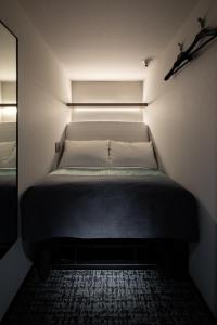 Cama pequeña en habitación pequeña con: en The Millennials Fukuoka, en Fukuoka