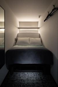 a small bed in a small room with at The Millennials Fukuoka in Fukuoka