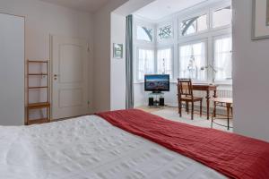 Schlafzimmer mit einem Bett, einem Tisch und einem TV in der Unterkunft Villa Eden Typ 4 Dependance in Binz