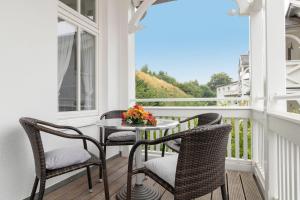 a balcony with two chairs and a table with flowers on it at Villa-Eden-Typ-4-Dependance in Binz