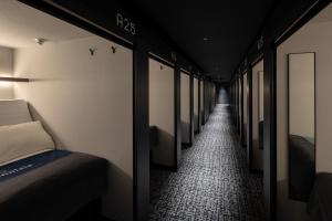 a hallway with a row of beds in a room at The Millennials Fukuoka in Fukuoka