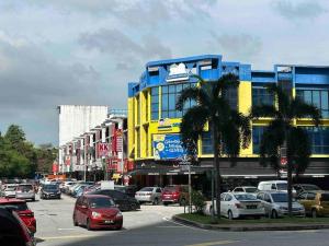 a yellow and blue building with cars parked in a parking lot at E2 Emporis KD Sunway Gize SOHO in Petaling Jaya