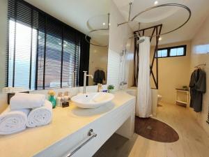 a bathroom with a sink and a large mirror at Cae Villa Hua Hin in Hua Hin