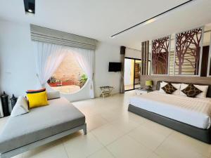 um quarto grande com 2 camas e um sofá em Cae Villa Hua Hin em Hua Hin