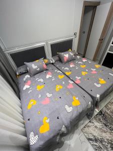 a bed with a gray comforter with ducks on it at Villa, Sea Front View منتجع قرية سما العريش in El Arish