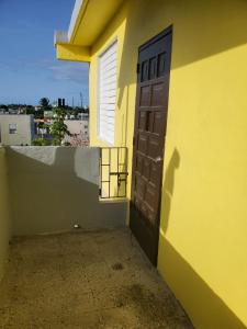 a door on the side of a yellow building at 310 Del Valle Central, Freshly Remodeled 3 Bedroom Home Sleeps 8 in San Juan