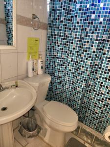 a bathroom with a white toilet and a sink at 310 Del Valle Central, Freshly Remodeled 3 Bedroom Home Sleeps 8 in San Juan