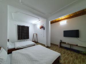 a bedroom with two beds and a flat screen tv at Cyan Sapa Homestay in Sapa