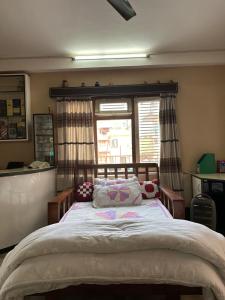 a bedroom with a large bed in front of a window at Lilen's Homestay - Casa Verde in Kathmandu