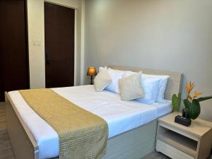 sypialnia z dużym łóżkiem z białą pościelą i poduszkami w obiekcie Mangolia Farm w mieście San Juan