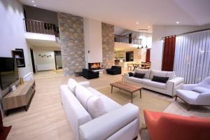 a living room with white furniture and a fireplace at Villa Queen Palm in Kumluca