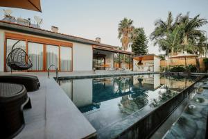 a swimming pool in front of a house at Villa Queen Palm in Kumluca