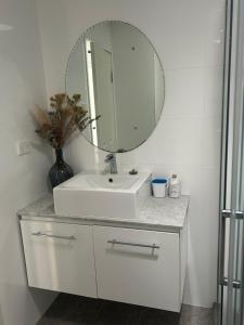 a bathroom with a white sink and a mirror at Whitfords Retreat - 2 Bedroom unit in Perth +22 photos