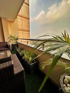 uma varanda com cadeiras e plantas num edifício em Two bedroom suite, Gold crest Mall em Lahore