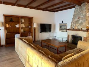 ein Wohnzimmer mit einem Sofa und einem Kamin in der Unterkunft Villa en Sanxenxo a pie de playa, Barreiros in Sanxenxo