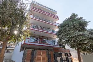 a building with a tree in front of it at Wandr Regor - Sector 38, Near Medicity Medanta in Gurgaon