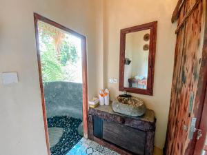 a bathroom with a sink and a mirror at Bali Inang Jungle View in Tampaksiring