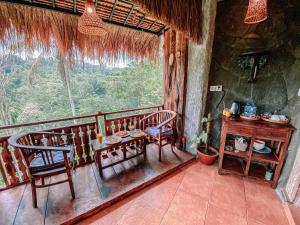 Zimmer mit 2 Stühlen, einem Tisch und einem Fenster in der Unterkunft Bali Inang Jungle View in Tampaksiring