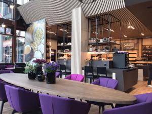 韋因費爾登的住宿－Hotel Thurgauerhof Self-Check-in，餐厅里的桌子和紫色椅子