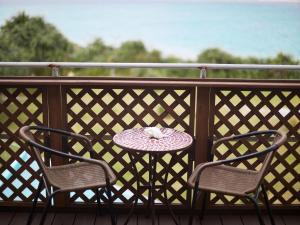 - un oiseau assis sur une table sur un balcon dans l'établissement Nagahama Beach Resort Kanon, à Nakijin