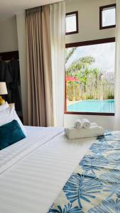a bedroom with a bed with two towels on it at Canal Village Pakpra Phatthalung in Phatthalung