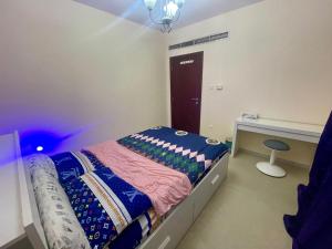 a small bedroom with a bed and a desk at Salahuddin Metro Home Stay in Dubai