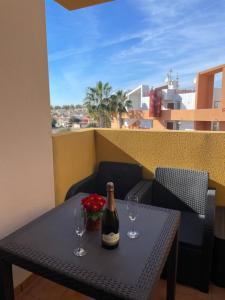 una botella de vino sentada en una mesa con dos copas en Apartamento en Playa Flamenca (residencial El Bosque), en Playas de Orihuela