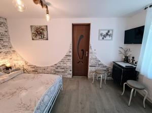 een slaapkamer met een bed, een bureau en een deur bij Casa de vacanta La Locanda Dubova in Dubova