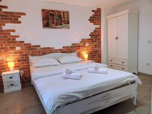 Un dormitorio con una cama y una pared de ladrillo. en Camere de inchiriat La Locanda, en Dubova