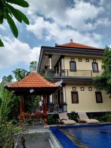 une maison avec une piscine en face de celle-ci dans l'établissement Puri Prana Guest House, à Ubud